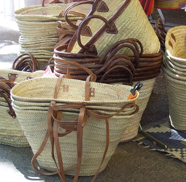 Stacked French market baskets with leather handles in various sizes and styles