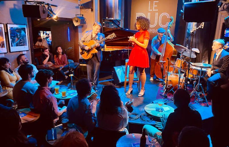 Intimate plush seating and candlelit tables at Le Duc des Lombards jazz club in Paris